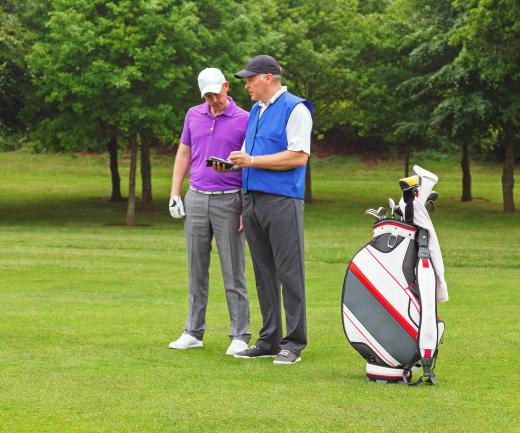 A caddy assists golfers with their equipment.